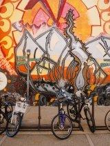 A bike rack in front of a large mural on Mead Hall.